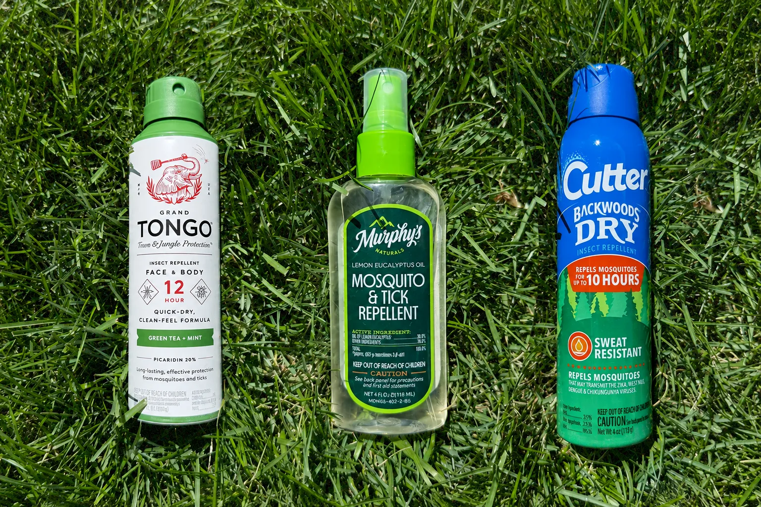 Three insect-repellent products arranged on grass
